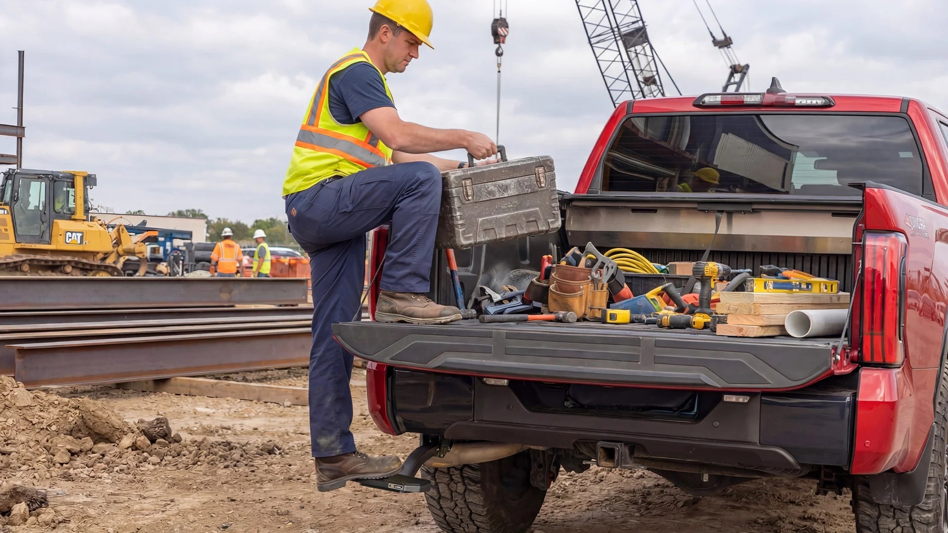 Wolfbox Heavy-Duty Bed Step at a construction job site - Effortlessly hauling tools and heavy equipment into the pickup bed.