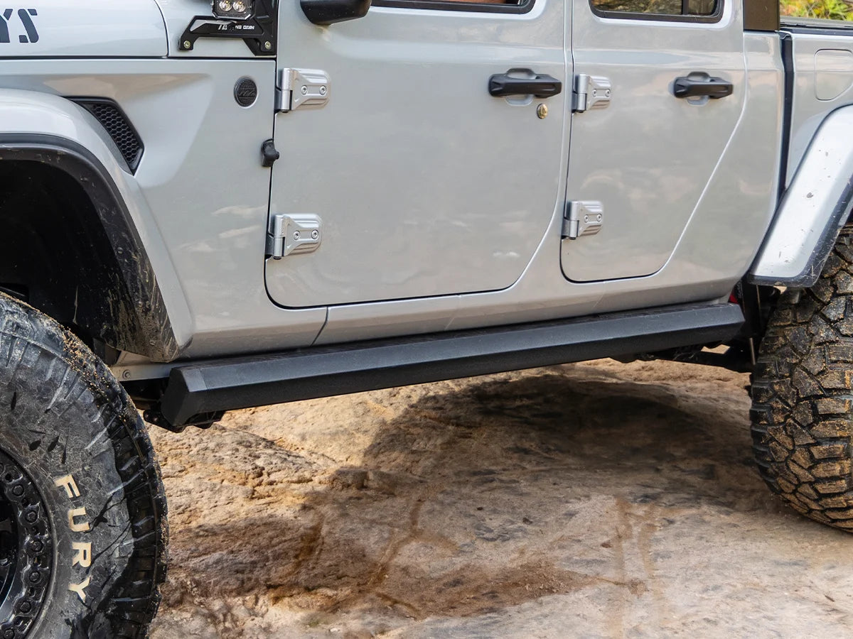 Wolfbox power running board retracted flush against a Jeep rocker panel, showing the clean factory look when the door is closed and the step is parked.