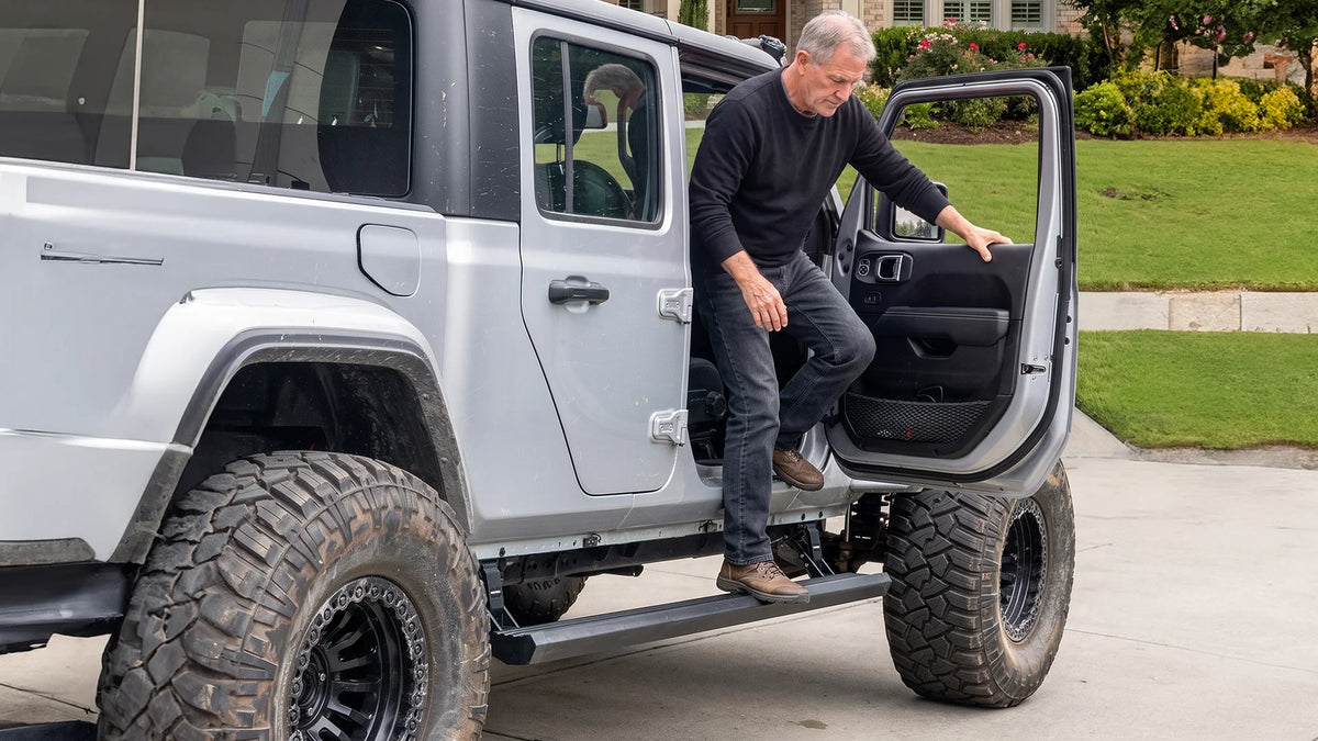 Older adult using a Wolfbox power side step to safely climb into a lifted Jeep, showing the low step height and stable footing for seniors and limited-mobility drivers.