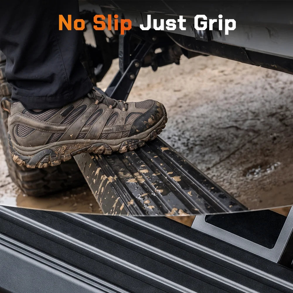 Close-up of a hiking boot stepping on a Wolfbox electric side step, demonstrating the non-slip textured surface for secure footing in wet or muddy conditions.