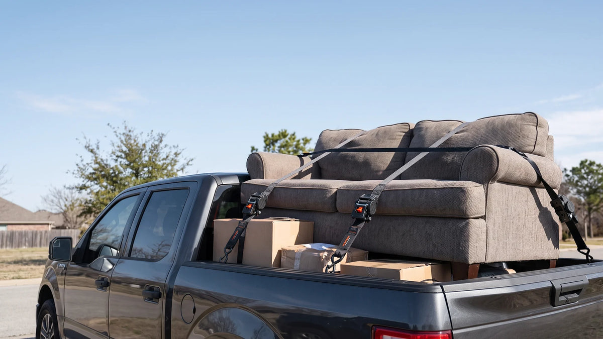 Cargo and gear bags held down in a pickup bed with retractable ratchet straps, a simple way to keep everything secure and tidy while driving.