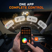Driver controlling a Wolfbox smart switch panel from a smartphone app in a darkened truck cab, with on-screen sliders for engine start, lights, brightness, and accessories.