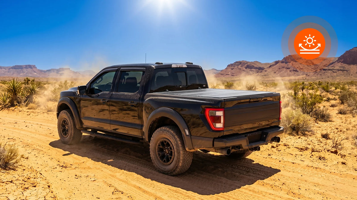 Weatherproof tri-fold hard truck bed cover with premium UV sun shield protection driving through a rugged, dusty wilderness trail under intense sunlight.
